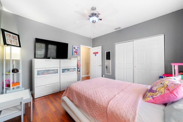 bedroom featuring a ceiling fan, a closet, visible vents, and dark wood-type flooring