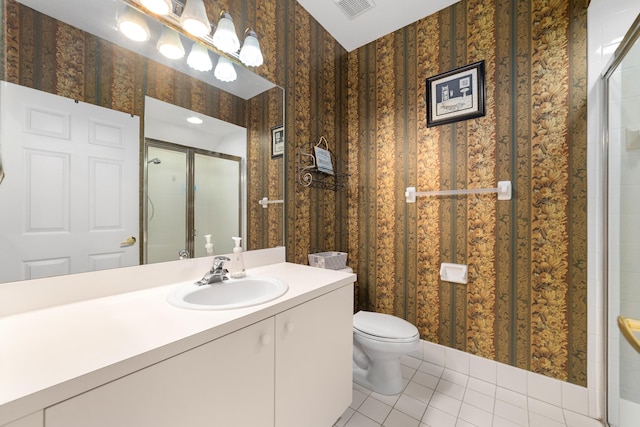 bathroom with a stall shower, toilet, and wallpapered walls