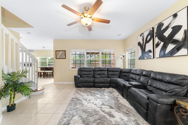 living area featuring ceiling fan, baseboards, and light tile patterned floors