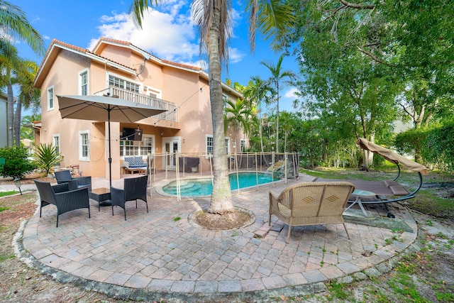 exterior space with a balcony, fence, a fenced in pool, stucco siding, and a patio area
