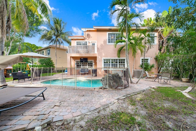 rear view of house featuring a fenced in pool, stucco siding, a patio area, fence, and cooling unit
