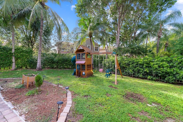 view of playground with a garden and a lawn