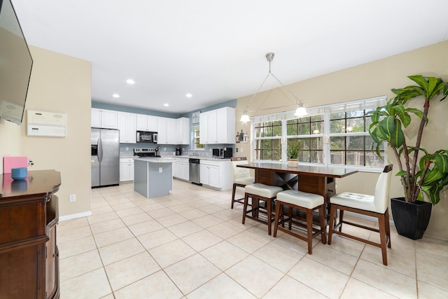 kitchen featuring light countertops, appliances with stainless steel finishes, light tile patterned flooring, and white cabinets