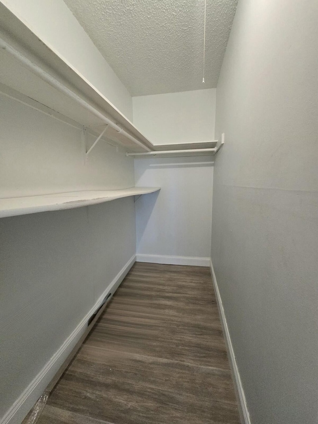 spacious closet featuring wood finished floors and attic access