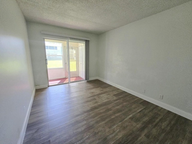 unfurnished room featuring dark wood-type flooring and baseboards