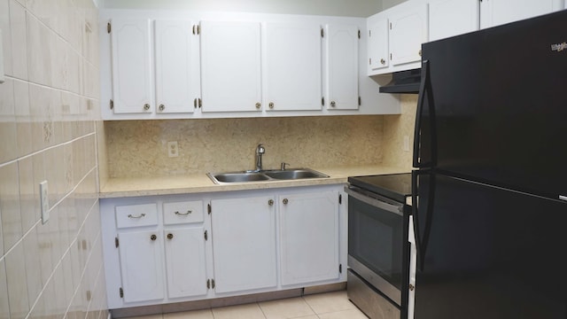 kitchen featuring freestanding refrigerator, under cabinet range hood, light countertops, stainless steel range with electric stovetop, and a sink