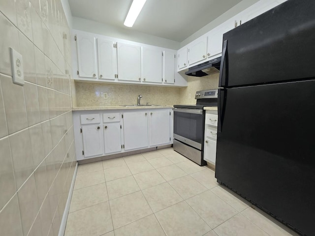 kitchen with white cabinets, freestanding refrigerator, stainless steel range with electric cooktop, under cabinet range hood, and light tile patterned flooring