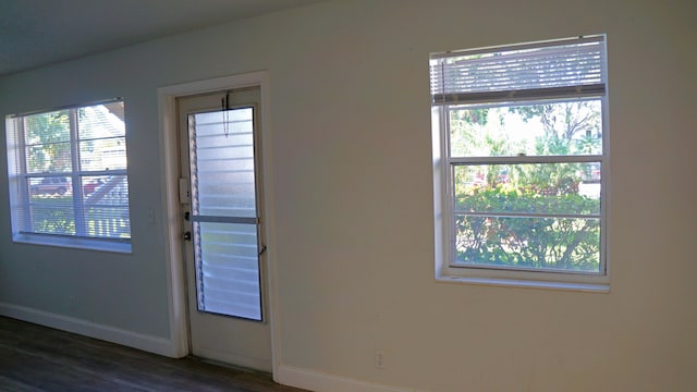 doorway to outside featuring dark wood finished floors and baseboards