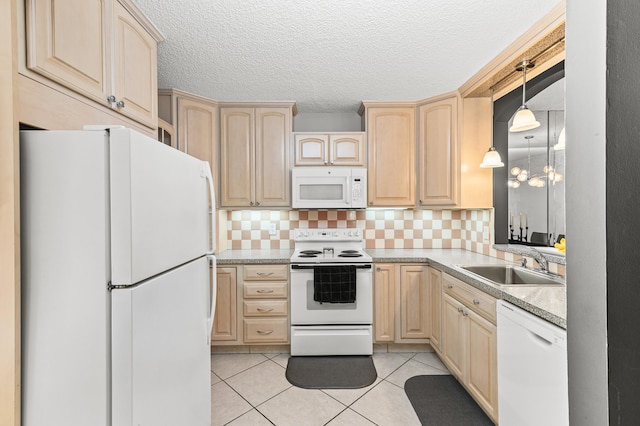 kitchen featuring white appliances, light tile patterned floors, light countertops, light brown cabinets, and a sink