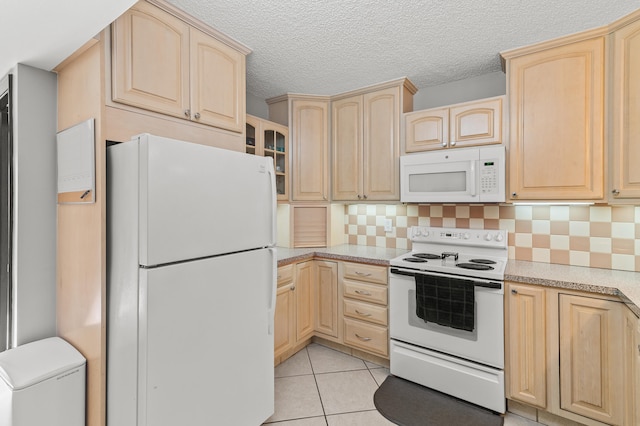 kitchen featuring light countertops, white appliances, light tile patterned floors, and light brown cabinetry