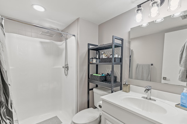 full bathroom featuring a stall shower, vanity, and toilet