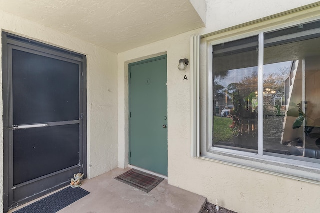 view of exterior entry featuring stucco siding