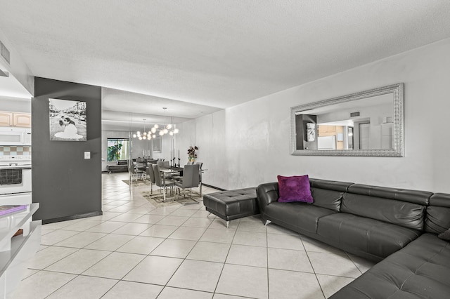 living area with a chandelier, a textured ceiling, and light tile patterned floors