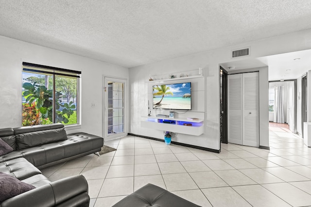 living room featuring light tile patterned floors, plenty of natural light, and visible vents