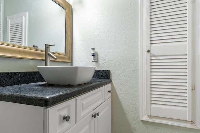 bathroom featuring a textured wall and vanity