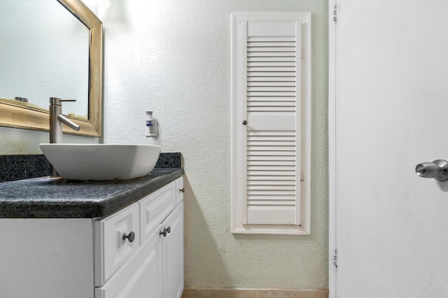 bathroom featuring a textured wall and vanity