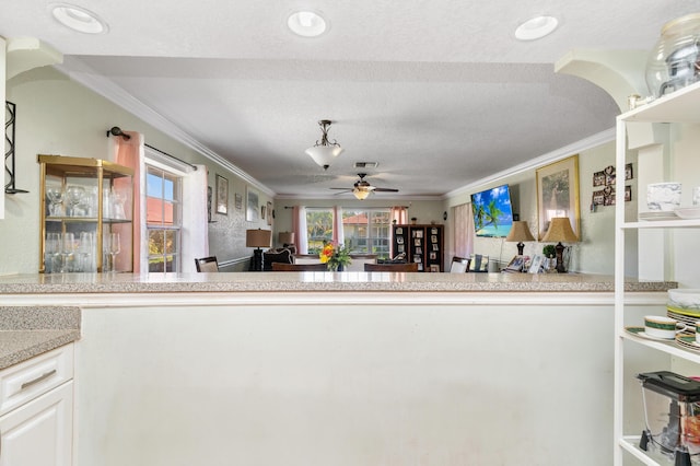 kitchen featuring open shelves, visible vents, ornamental molding, a ceiling fan, and a textured ceiling