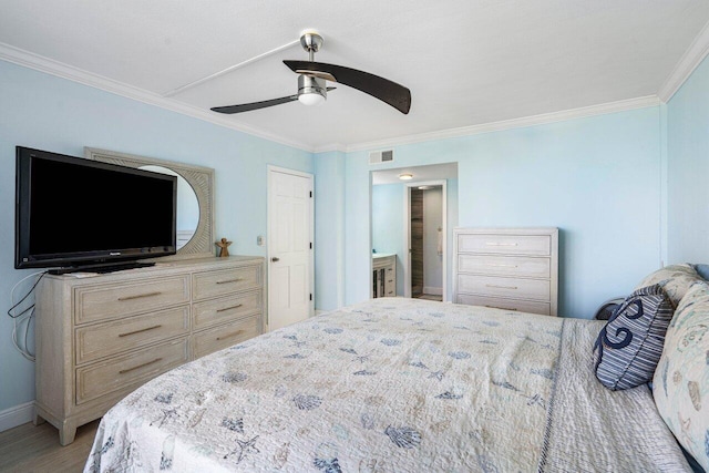 bedroom featuring light wood-type flooring, visible vents, connected bathroom, and ornamental molding