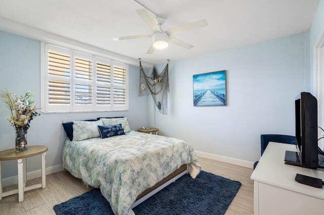 bedroom with light wood-style floors, baseboards, and a ceiling fan