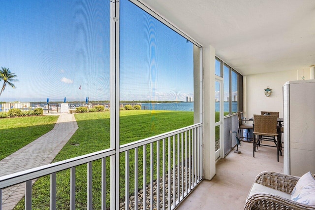 sunroom / solarium featuring a water view