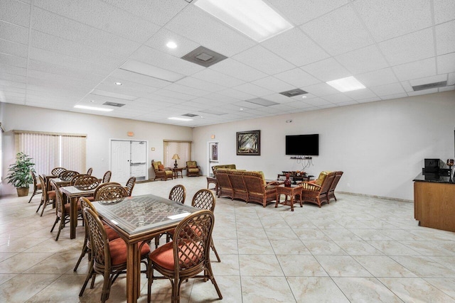 dining room featuring a drop ceiling, visible vents, and light tile patterned floors