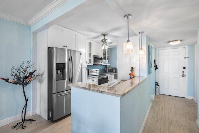 kitchen featuring light wood-style flooring, appliances with stainless steel finishes, glass insert cabinets, white cabinetry, and a peninsula