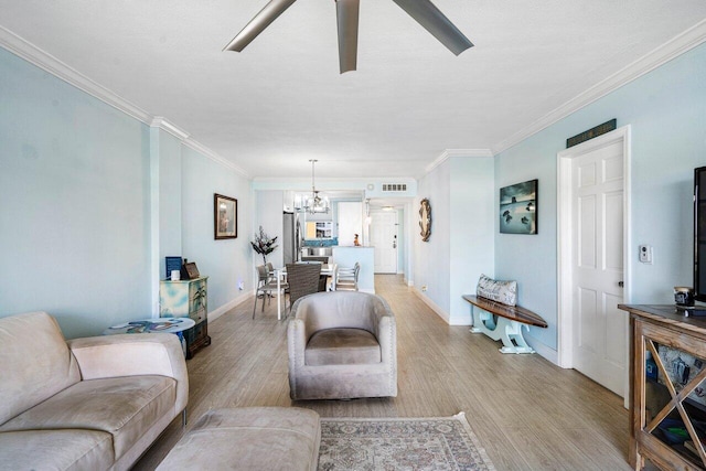 living area with light wood finished floors, visible vents, baseboards, and crown molding