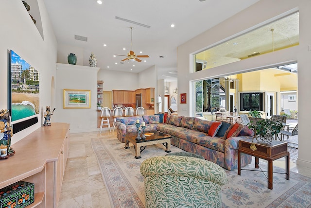 living area featuring marble finish floor, a high ceiling, visible vents, and recessed lighting