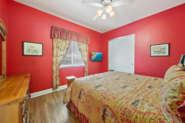 bedroom featuring ceiling fan, wood finished floors, and baseboards