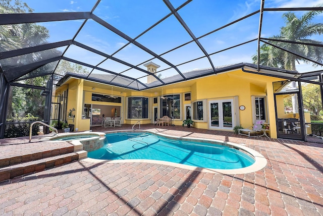 view of pool with a lanai, a patio area, a pool with connected hot tub, and french doors