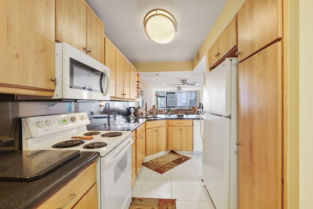 kitchen with white appliances, light tile patterned floors, dark countertops, light brown cabinetry, and a sink