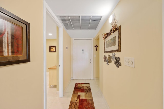 hall featuring visible vents, baseboards, and light tile patterned floors