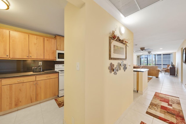 kitchen featuring light tile patterned flooring, white appliances, visible vents, decorative backsplash, and dark countertops