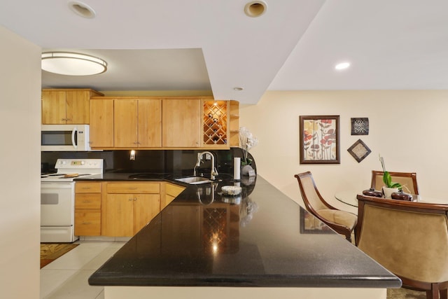 kitchen with light tile patterned floors, recessed lighting, a sink, white appliances, and a peninsula