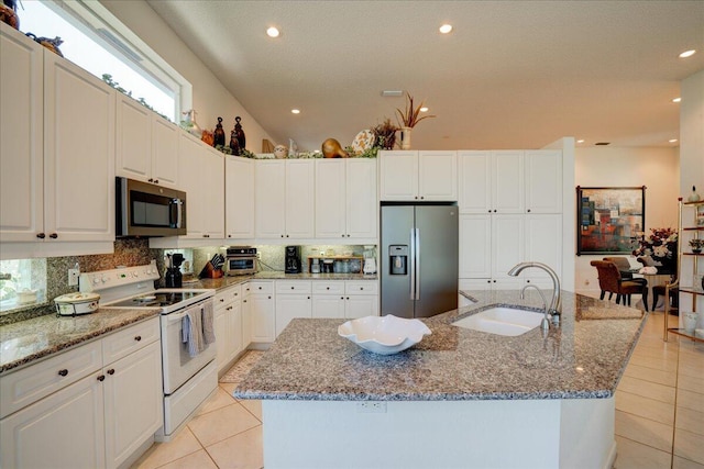 kitchen with a sink, stainless steel appliances, tasteful backsplash, and light tile patterned flooring