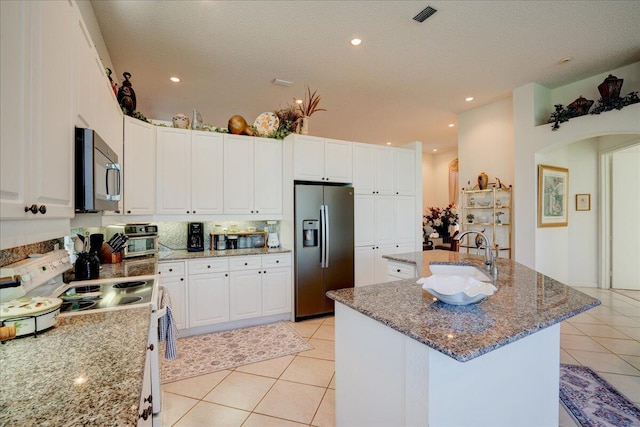 kitchen featuring an island with sink, electric stove, a sink, light tile patterned flooring, and stainless steel fridge with ice dispenser