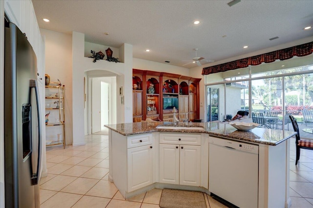 kitchen featuring light tile patterned floors, white cabinetry, a sink, stainless steel refrigerator with ice dispenser, and dishwasher