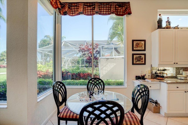 dining space featuring light tile patterned floors and baseboards