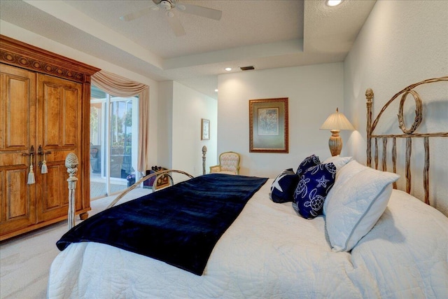 bedroom with a tray ceiling, light carpet, a ceiling fan, and access to outside