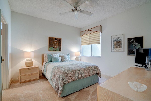 bedroom featuring a textured ceiling, ceiling fan, baseboards, and light carpet