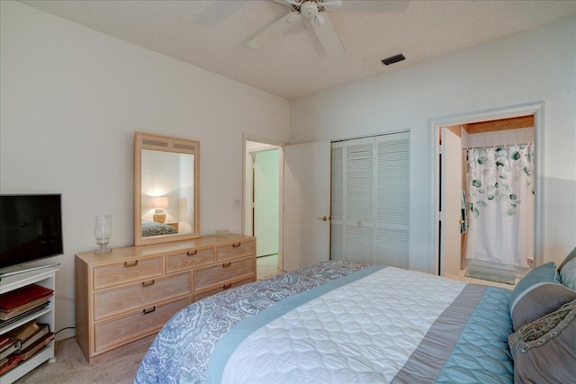 bedroom featuring light carpet, visible vents, a textured ceiling, and a closet