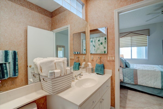 full bath with vanity, ensuite bath, a ceiling fan, and wallpapered walls