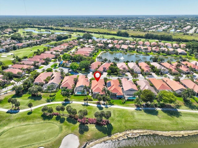 drone / aerial view featuring a residential view, golf course view, and a water view