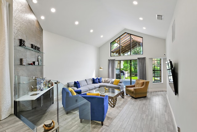 living room with high vaulted ceiling, recessed lighting, visible vents, baseboards, and wood tiled floor