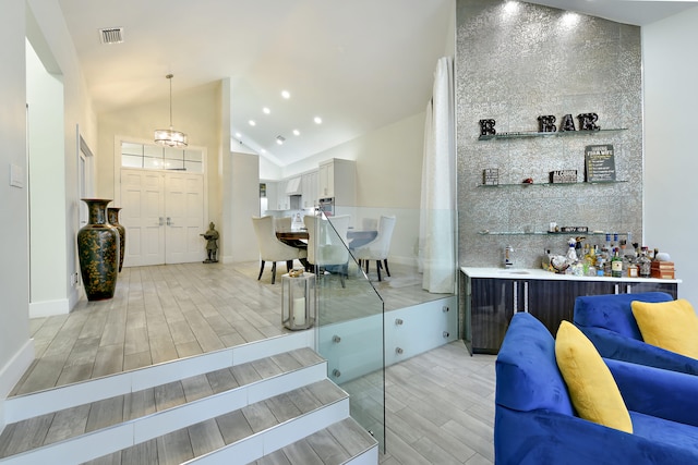 interior space with high vaulted ceiling, light wood finished floors, visible vents, and recessed lighting