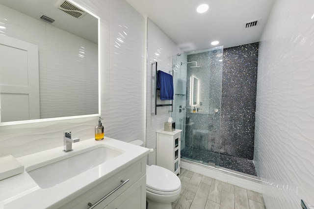 full bathroom featuring toilet, a tile shower, visible vents, and tile walls