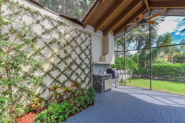 unfurnished sunroom with plenty of natural light, ceiling fan, and lofted ceiling with beams