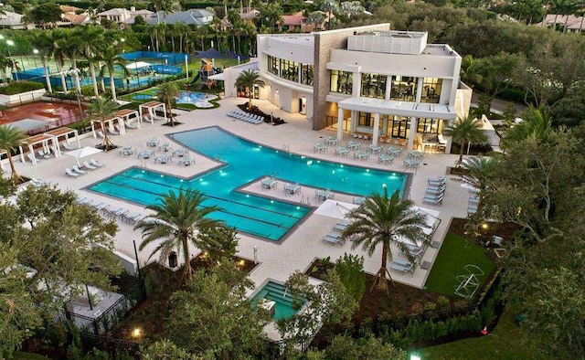 rear view of house featuring a balcony, a patio, fence, and a community pool