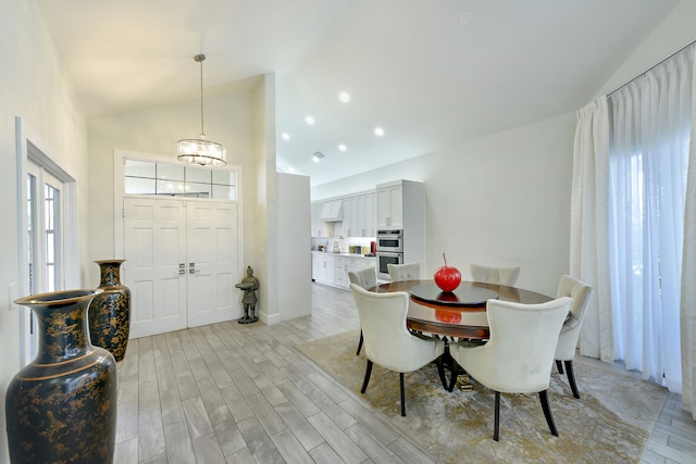 dining space with high vaulted ceiling, light wood-type flooring, and recessed lighting