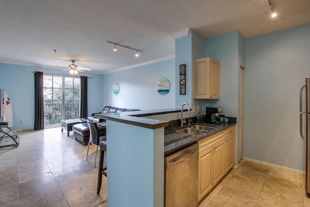 kitchen featuring appliances with stainless steel finishes, a breakfast bar, ornamental molding, a textured ceiling, and a sink